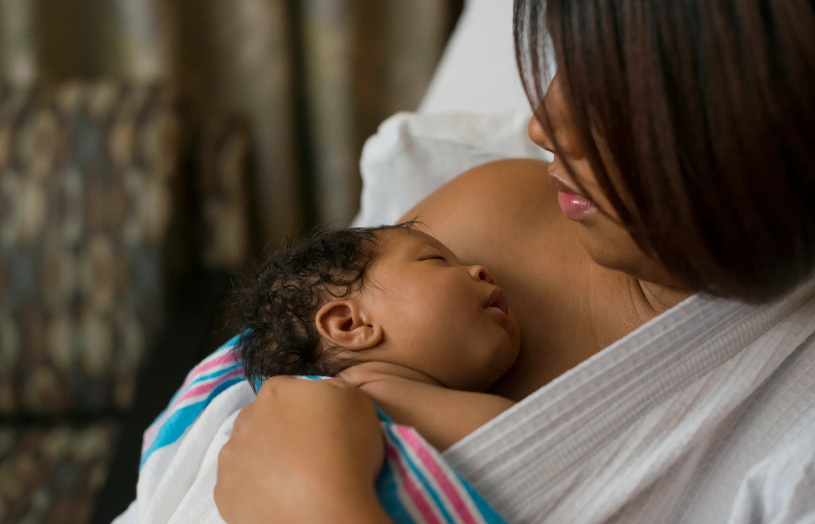 A mother with her newborn baby laying on her bare chest. 