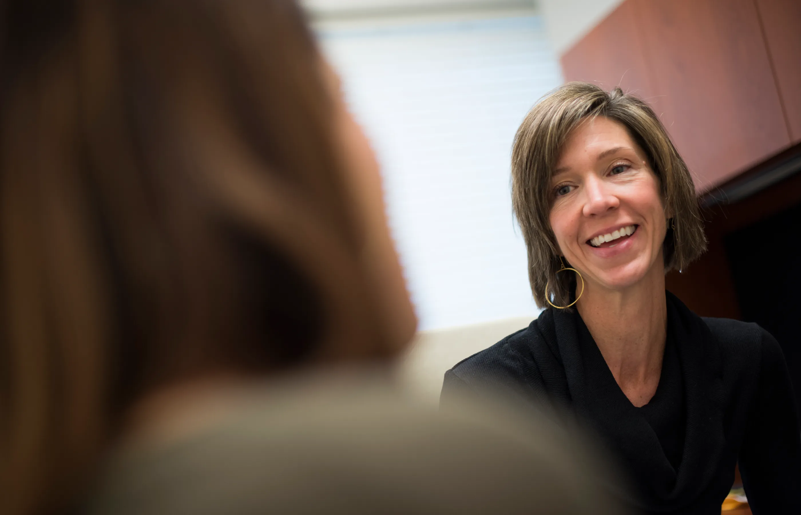 A Novant Health provider is smiling as she is talking with a patient. 