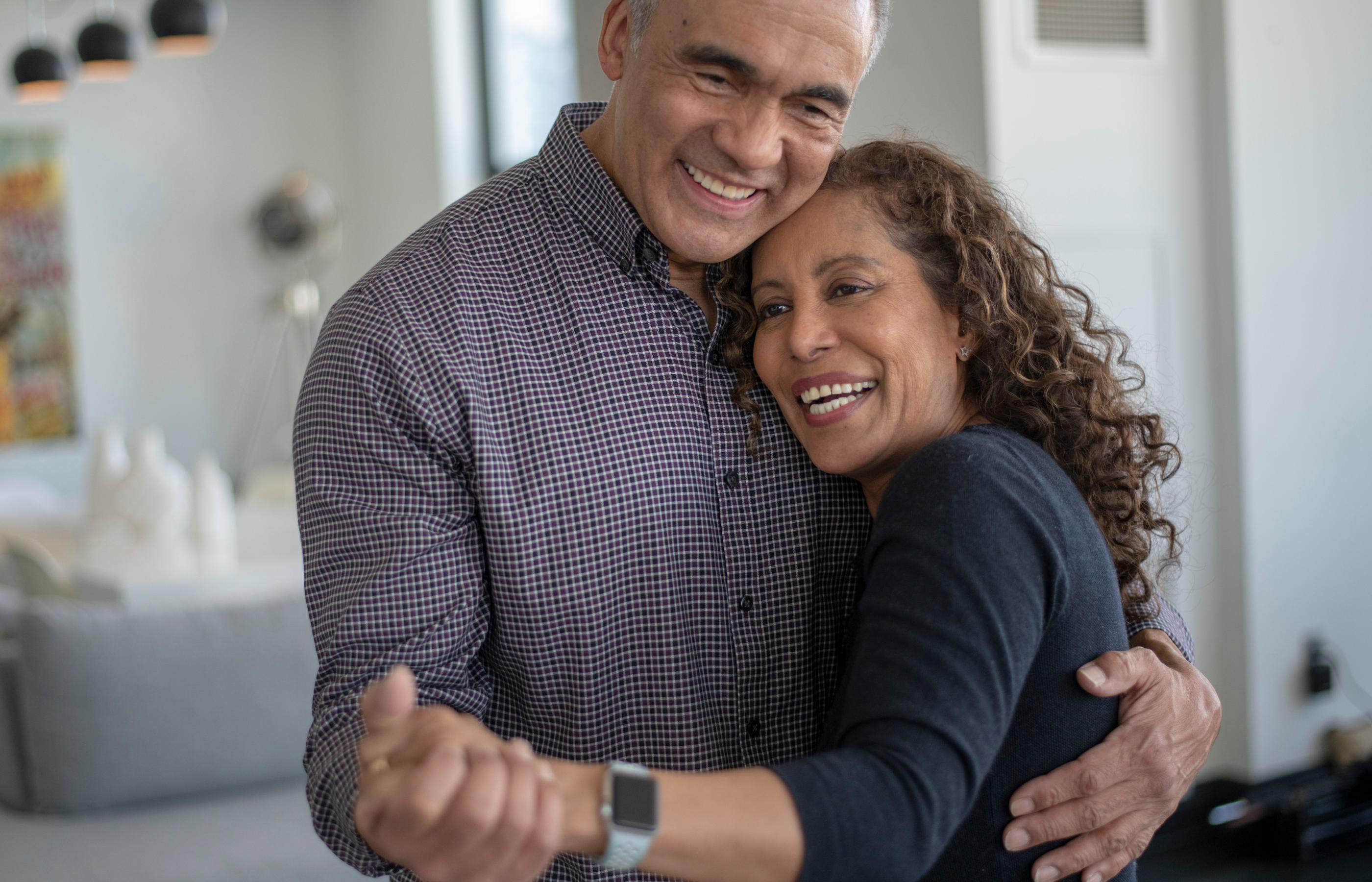 A man and a woman dancing closely at home.
