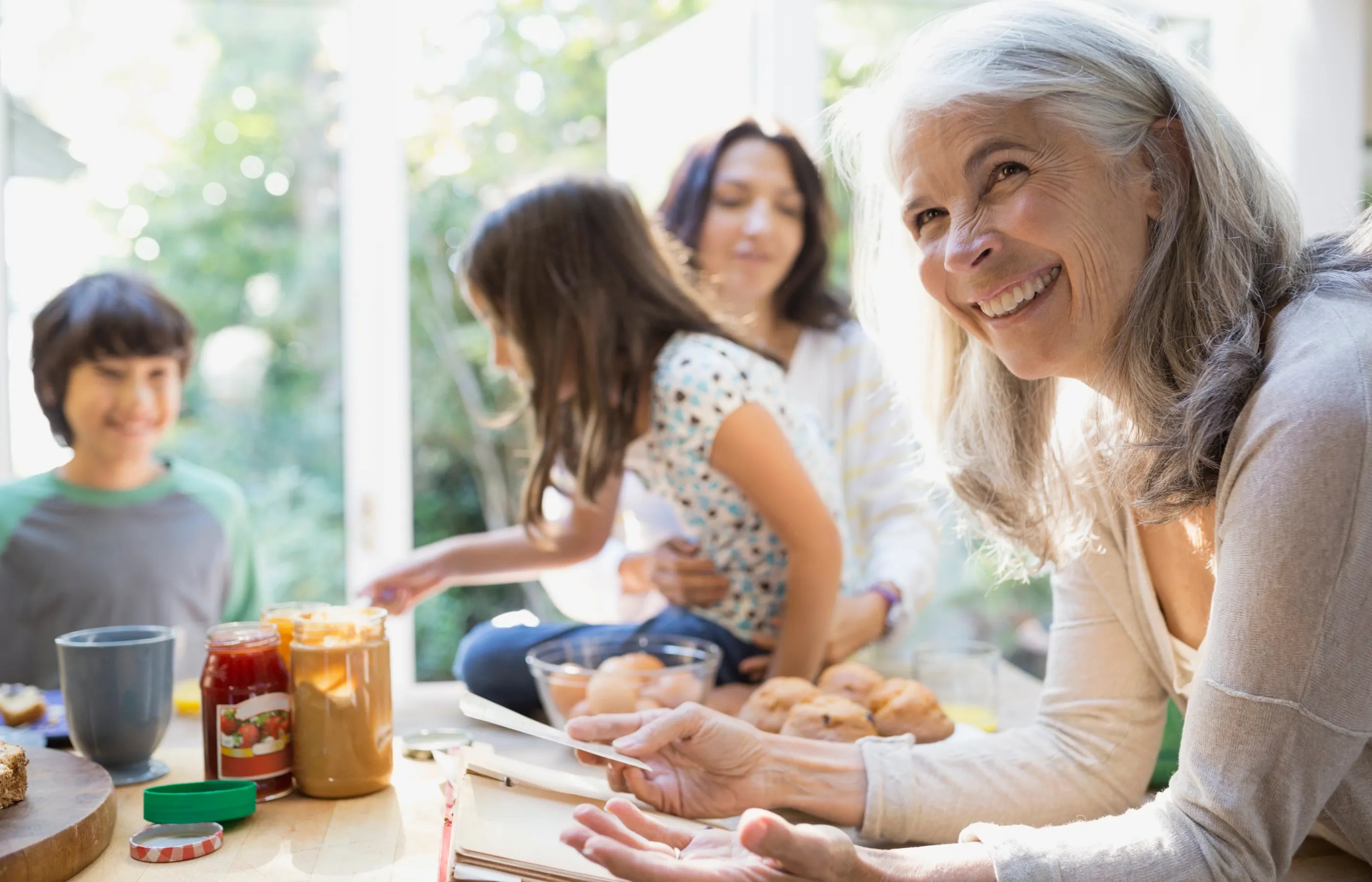 Happy grandmother, daughter and grandchildren having fun while baking in the kitchen