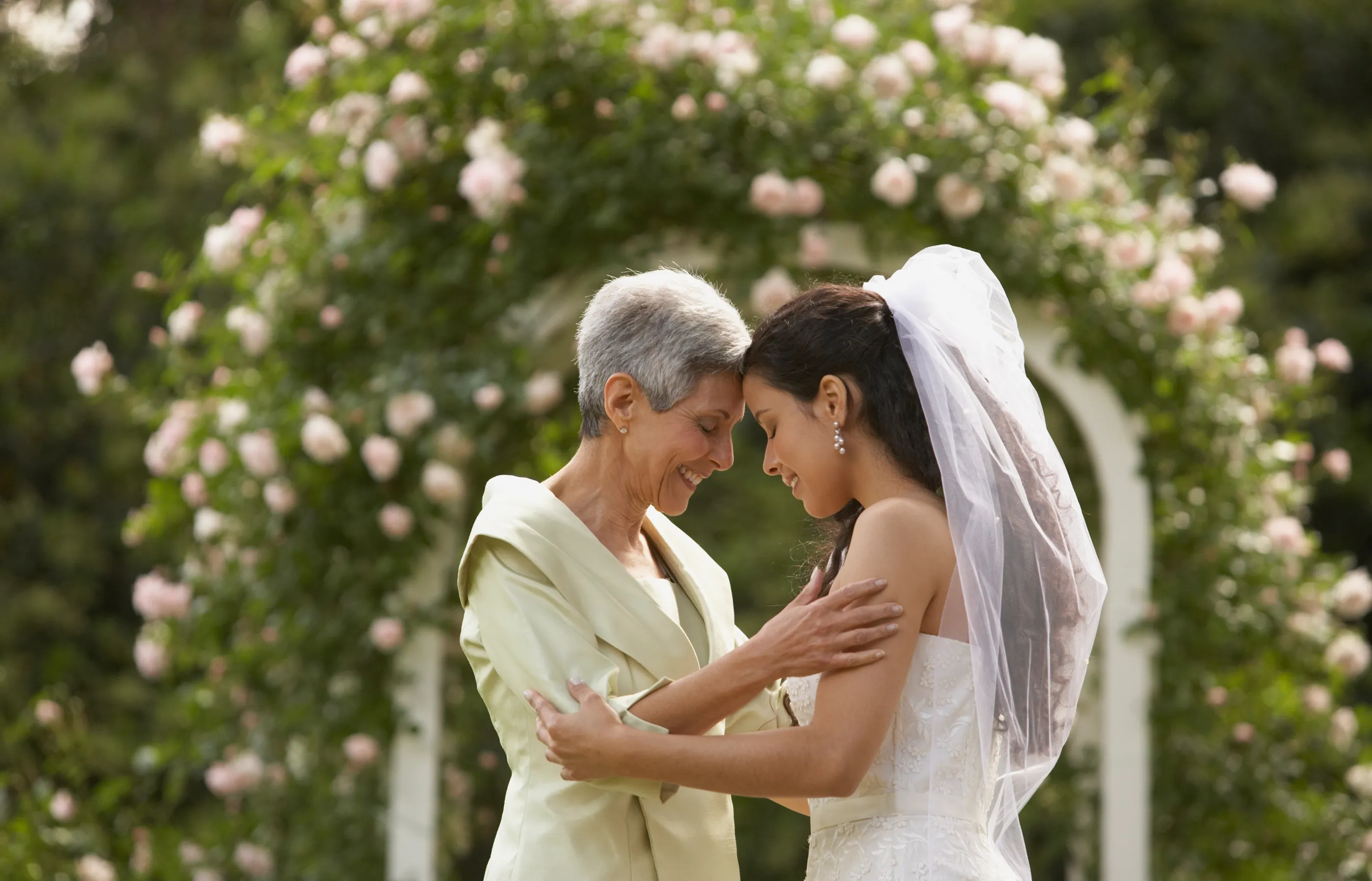 Mother holding bride during her wedding day.