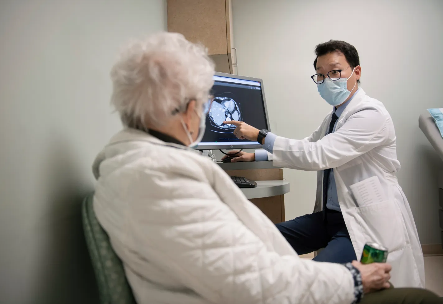 Dr. An is reviewing a scan with a patient. Dr. An is reviewing a scan with a patient.