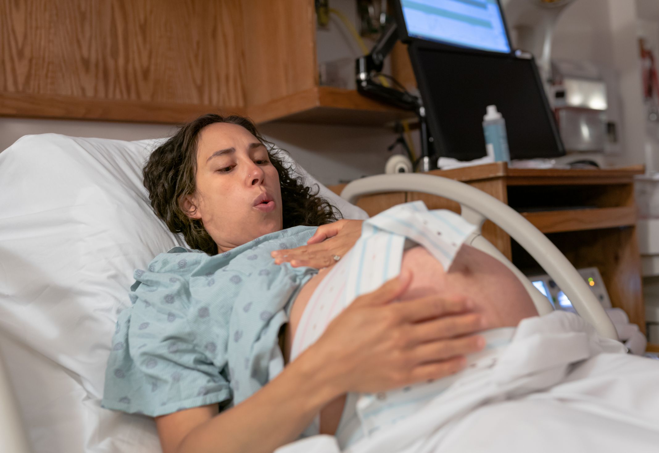 Mom in Novant Health labor & delivery suite doing breathing exercises
