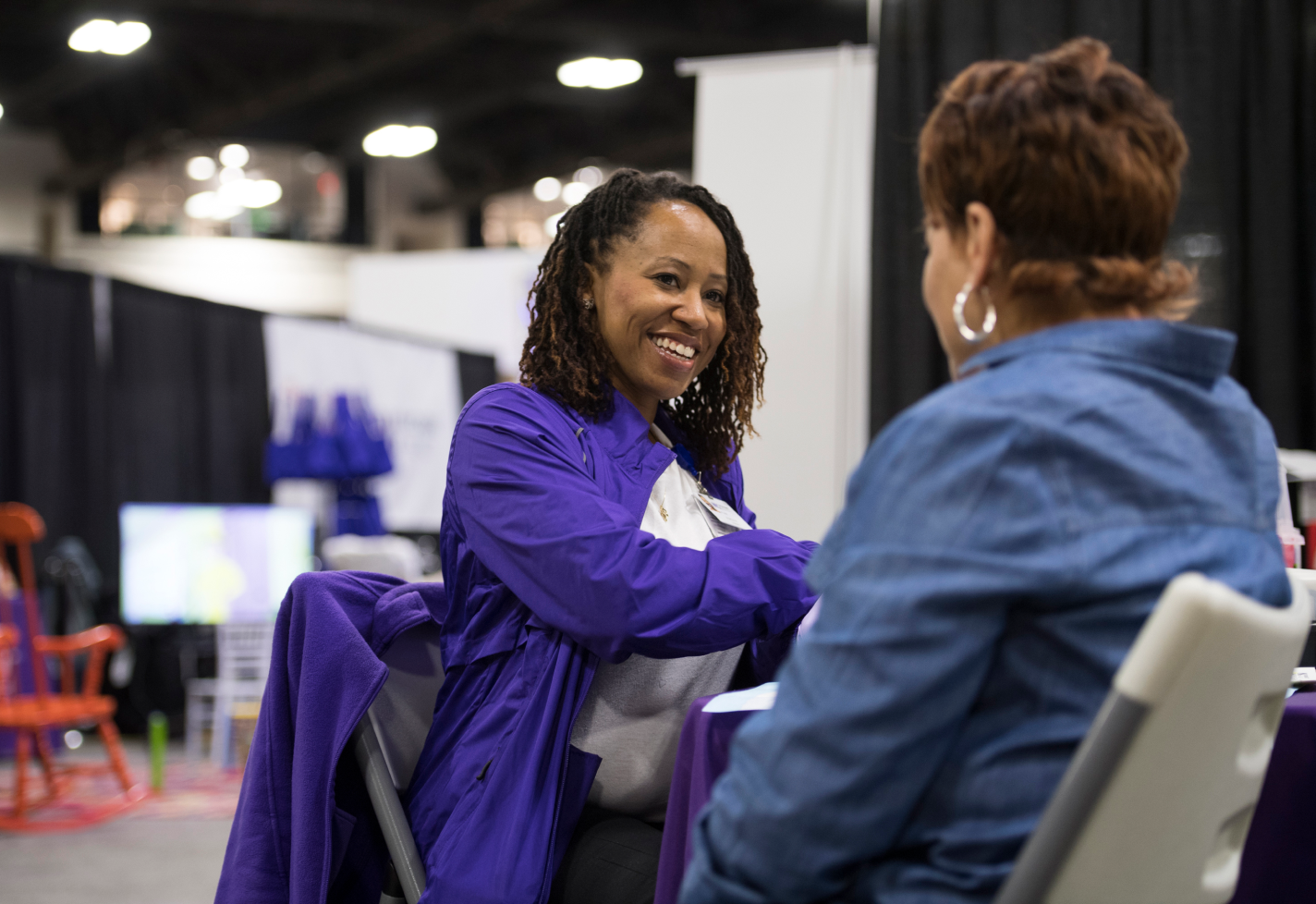 Team member speaking with a woman at a community care event.