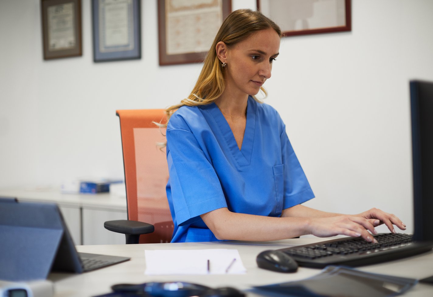 Woman sitting in an office typing on a computer