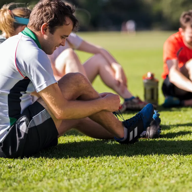 Soccer player tying his shoe before a match. Soccer player tying his shoe before a match.